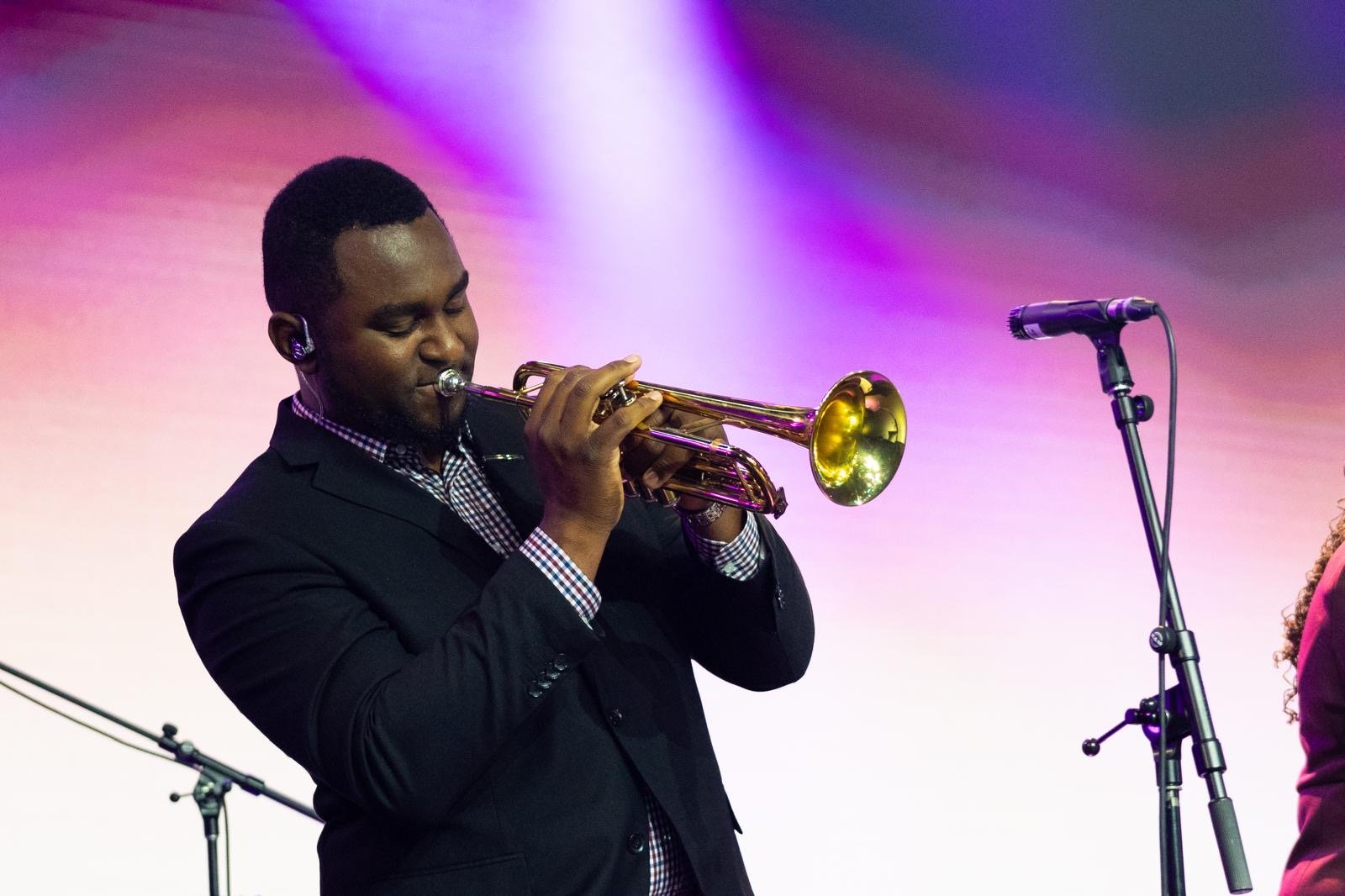 Jean Caleb Joseph performing on trumpet during worship.